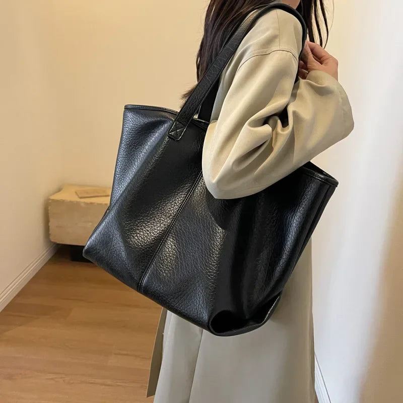 Sac à main KIM en cuir synthétique noir, moderne et pratique, grand sac tote bag avec intérieur spacieux et finitions soignées, parfait pour le quotidien et le travail, porté épaule.