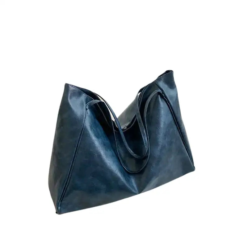 Sac à main LORIA en cuir synthétique bleu, moderne et chic, avec bandoulière ajustable, intérieur spacieux et compartiments organisés, parfait pour le quotidien et les sorties.